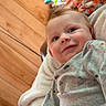 Axl joined the competition — help win amazing prizes! baby, smile, infant, blanket, wooden_wall, clothing, cozy, indoors, cute, child, portrait, happy, toy, colorful, face, person, warm, casual, relax, comfort
