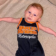 Axl joined the competition — help win amazing prizes! baby, infant, harley_davidson, romper, clothing, couch, furniture, indoor, person, child, cute, arm, face, head, expression, relaxed, comfort, textile, pattern, skin