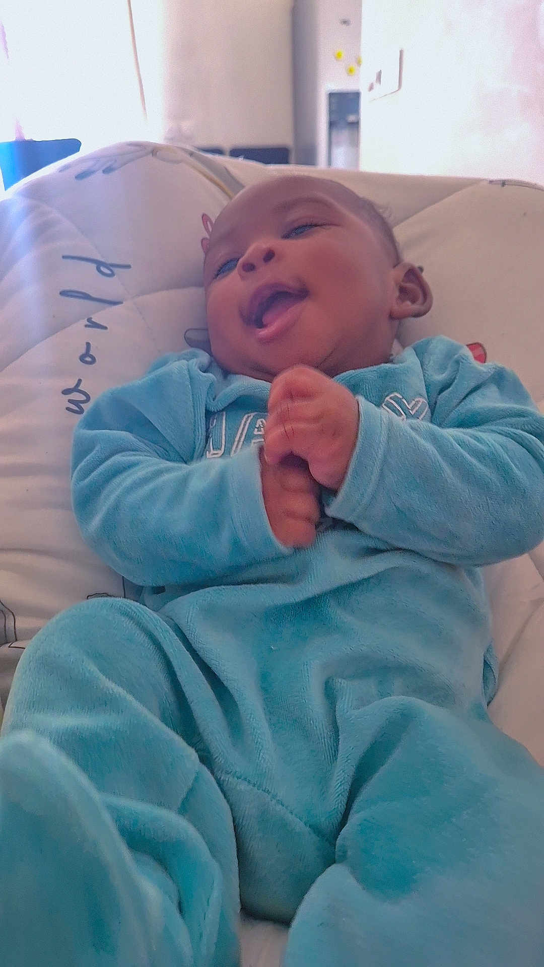 Wiliel participe au concours pour gagner de l'argent avec cette photo : baby, infant, smiling, blue_clothing, cushion, indoor, happy, person, child, young, soft_light, relaxing, face, hand, footwear, cozy, cute, portrait, babywear, comfort