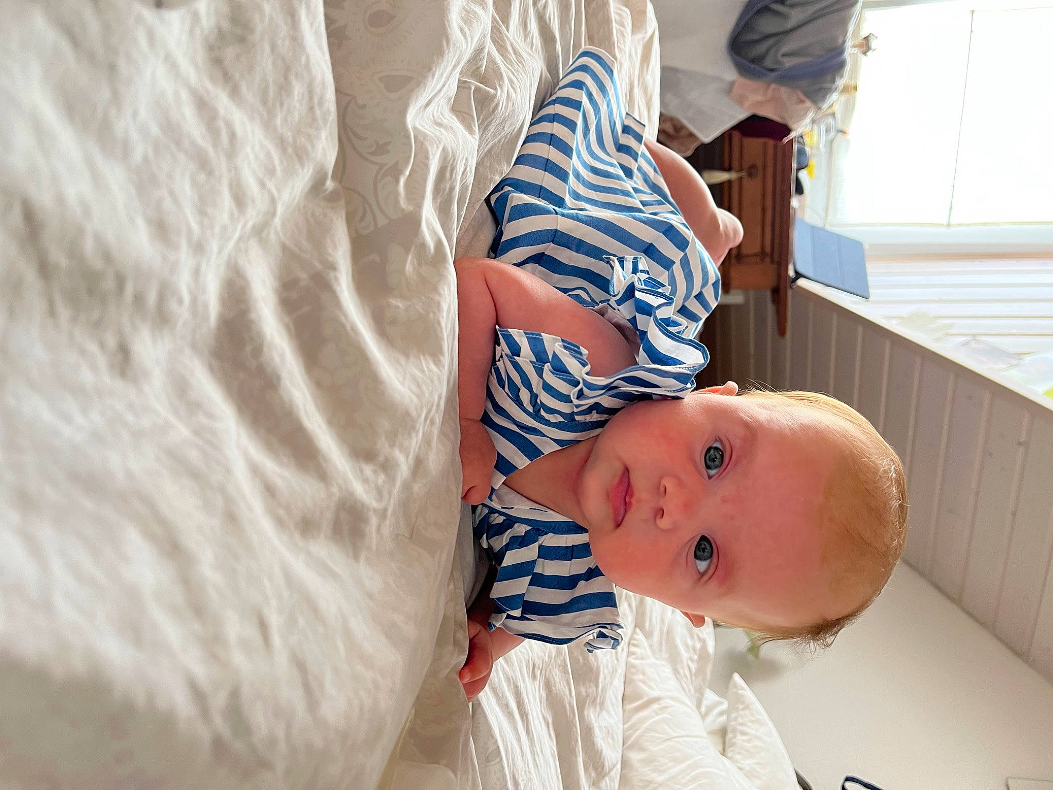 Eleanor participe au concours pour gagner de l'argent avec cette photo : baby, baby_products, baby_toddler_clothing, child, comfort, dress, elbow, happy, hat, human_body, human_leg, linens, nail, pattern, person, sleeve, smile, toddler, window, wood