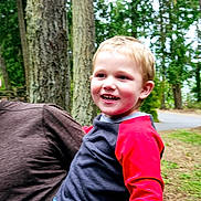 Carson joined the competition — help win amazing prizes! child, smiling, outdoor, trees, person, forest, nature, happy, holding, casual, boy, jeans, red_shirt, adult_hand, daylight, park, greenery, walking_path, portrait, fun