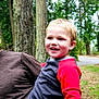 child, smiling, outdoor, trees, person, forest, nature, happy, holding, casual, boy, jeans, red_shirt, adult_hand, daylight, park, greenery, walking_path, portrait, fun