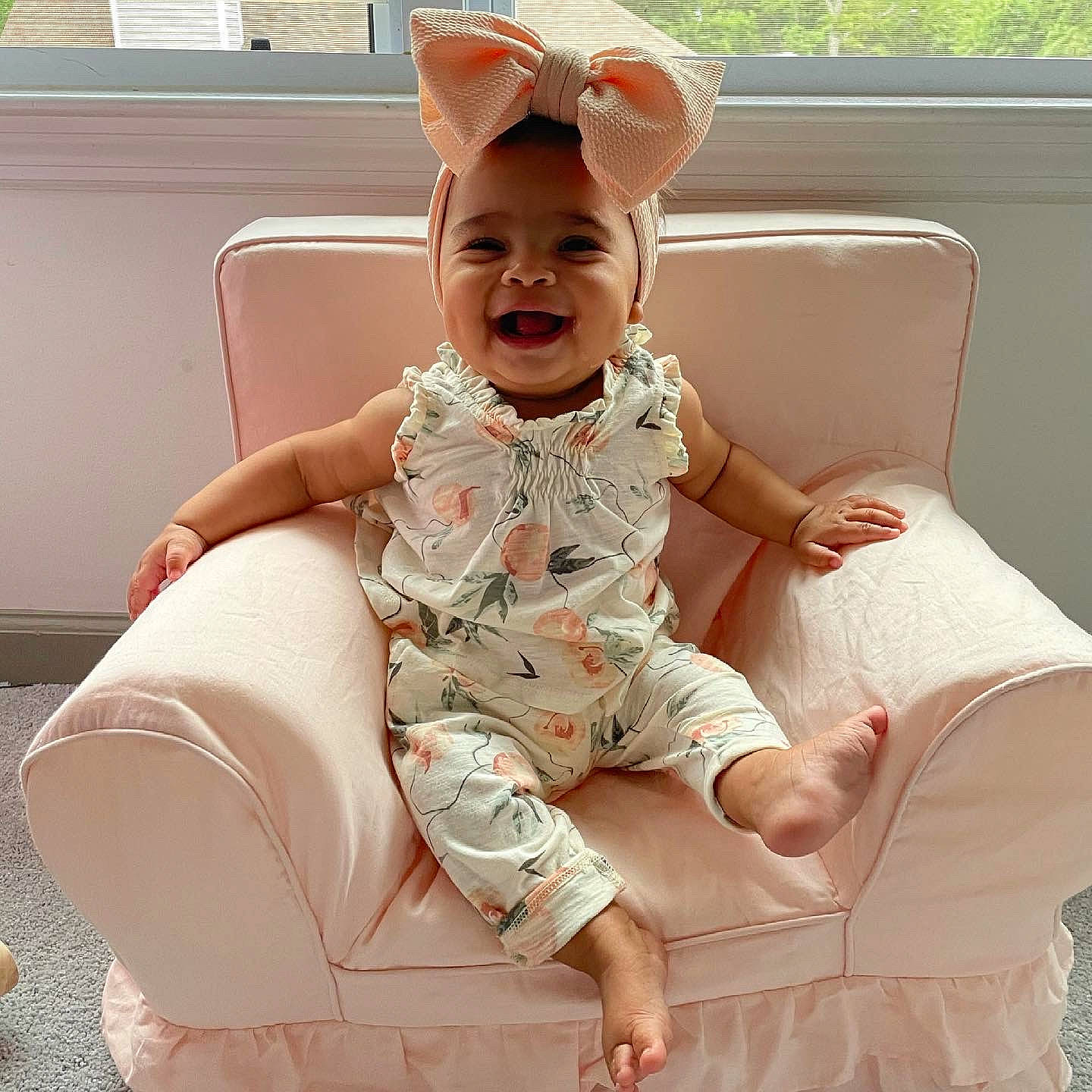 Geneva is registered to the contest to win money with this photo: baby, baby_toddler_clothing, child, comfort, dress, face, hand, happy, head, headgear, human_body, human_leg, joy, pattern, person, pink, sitting, skin, sleeve, smile