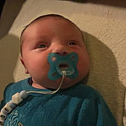 Manoë participe au concours pour gagner de l'argent avec cette photo : baby, blanket, blue_clothing, child, closeup, comfort, cute, expression, face, head, indoor, infant, lying_down, newborn, pacifier, person, portrait, soft_texture, toddler, warm_lighting