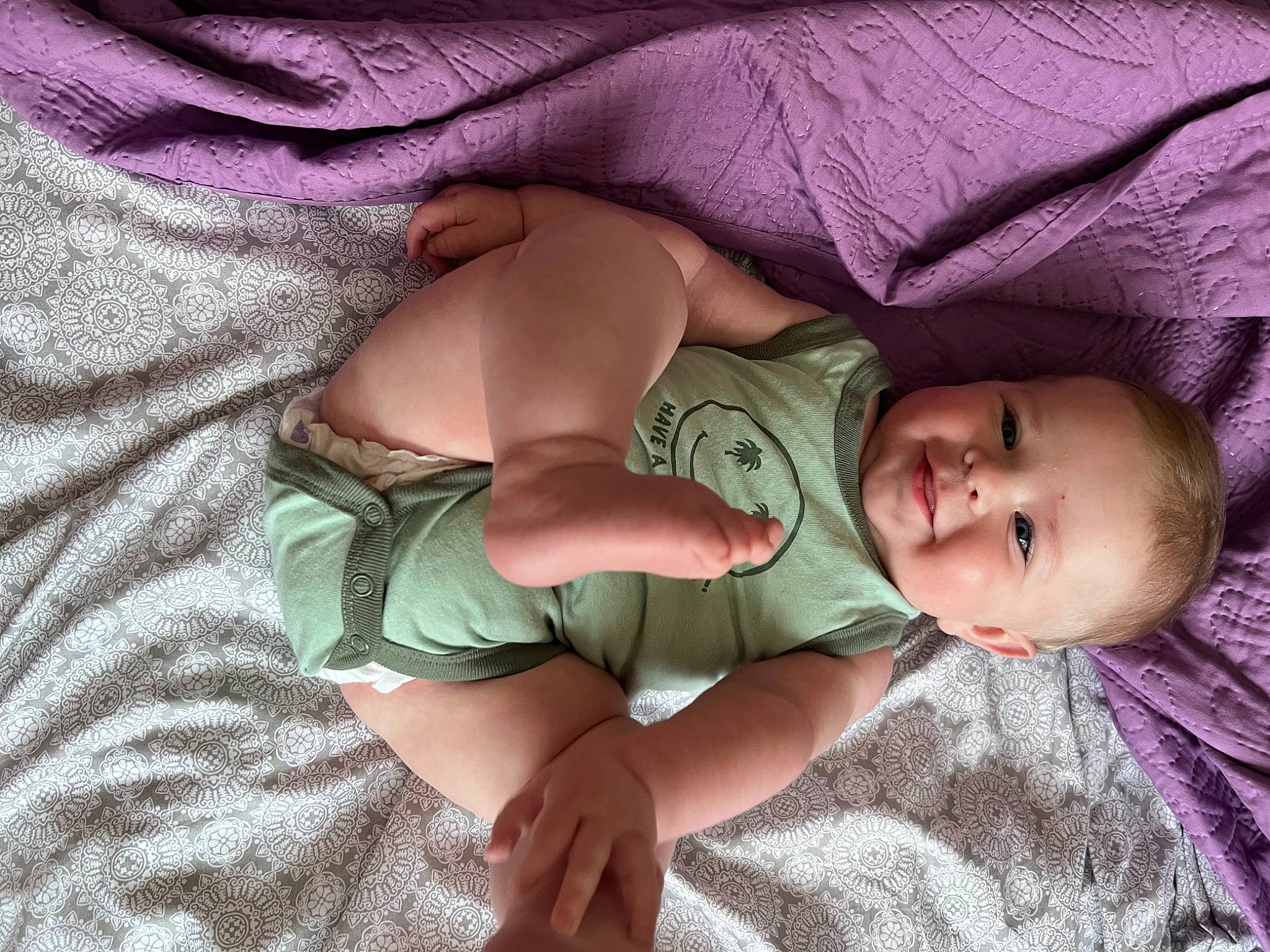 Dusty is registered to the contest to win money with this photo: arm, baby, baby_toddler_clothing, cheek, comfort, eye, finger, hand, head, human_body, joy, leg, linens, mouth, nose, pattern, person, skin, sleeve, smile