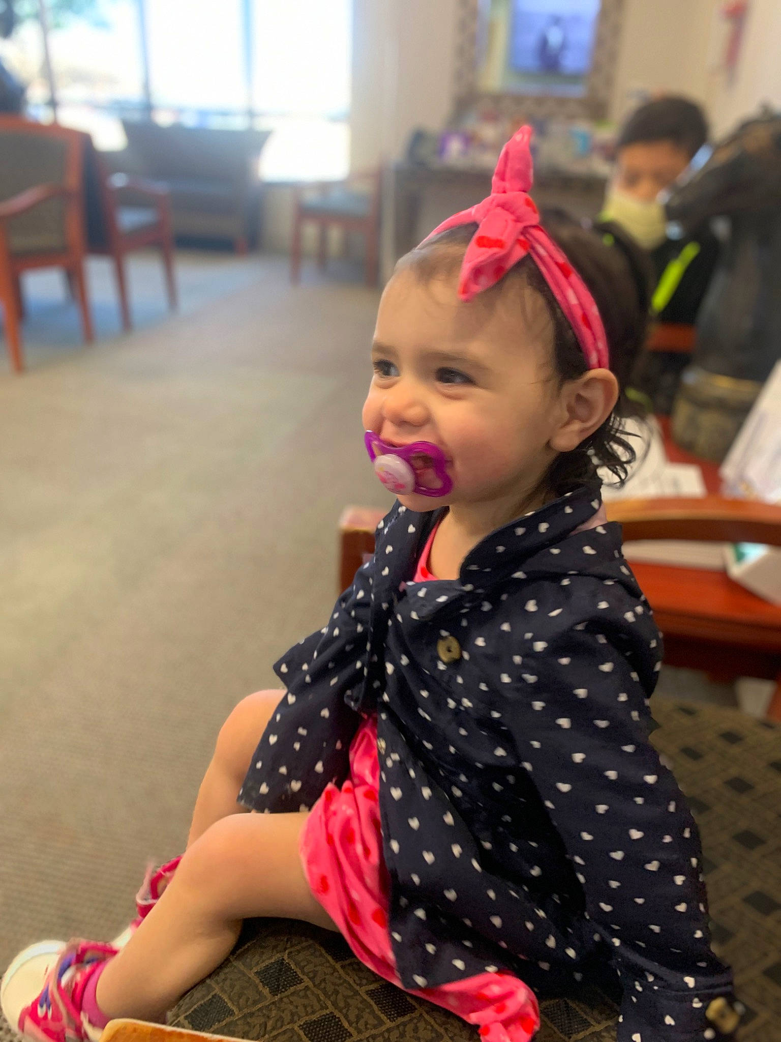 Riley is registered to the contest to win money with this photo: blurred, chair, child, entertainment, event, face, fashion_accessory, fashion_design, fun, hairstyle, happy, human_leg, knee, leisure, pattern, person, sitting, skin, smile, snapshot