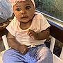 Rosa is registered to the contest to win money with this photo: baby, child, headband, flower, pink, shirt, pants, foot, chair, window, indoor, person, curious, expression, sitting, furniture, clothing, skin, hand, portrait