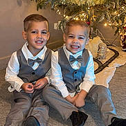 Giulian a rejoint le concours — aidez-le/la à gagner de superbes lots ! child, boys, christmas_tree, ornaments, lights, carpet, suit, bow_tie, smile, holiday, festive, indoor, decorations, happy, siblings, portrait, celebration, family, seasonal, toddler