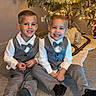 child, boys, christmas_tree, ornaments, lights, carpet, suit, bow_tie, smile, holiday, festive, indoor, decorations, happy, siblings, portrait, celebration, family, seasonal, toddler