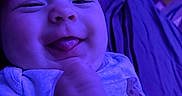 Lakelyn joined the competition — help win amazing prizes! baby, infant, tongue_out, blue_light, close_up, happy, smiling, clothing, onesie, hand, face, skin, indoors, bed, blanket, cute, child, person, portrait, playful