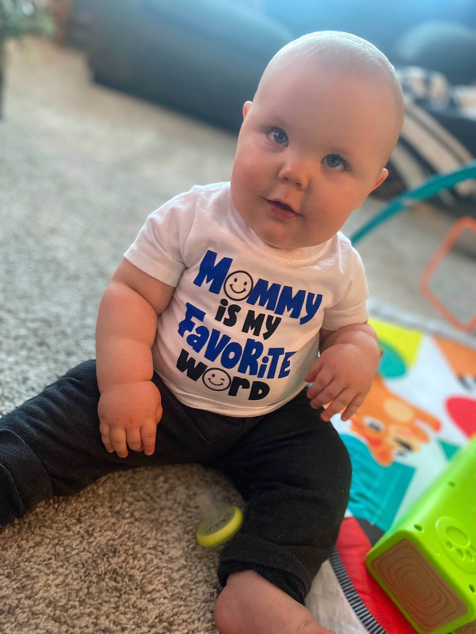 Cayson is registered to the contest to win money with this photo: baby, baby_playing_with_toys, baby_toddler_clothing, child, electric_blue, finger, floor, flooring, fun, grass, happy, human_leg, leg, leisure, person, sitting, skin, sleeve, smile, t_shirt