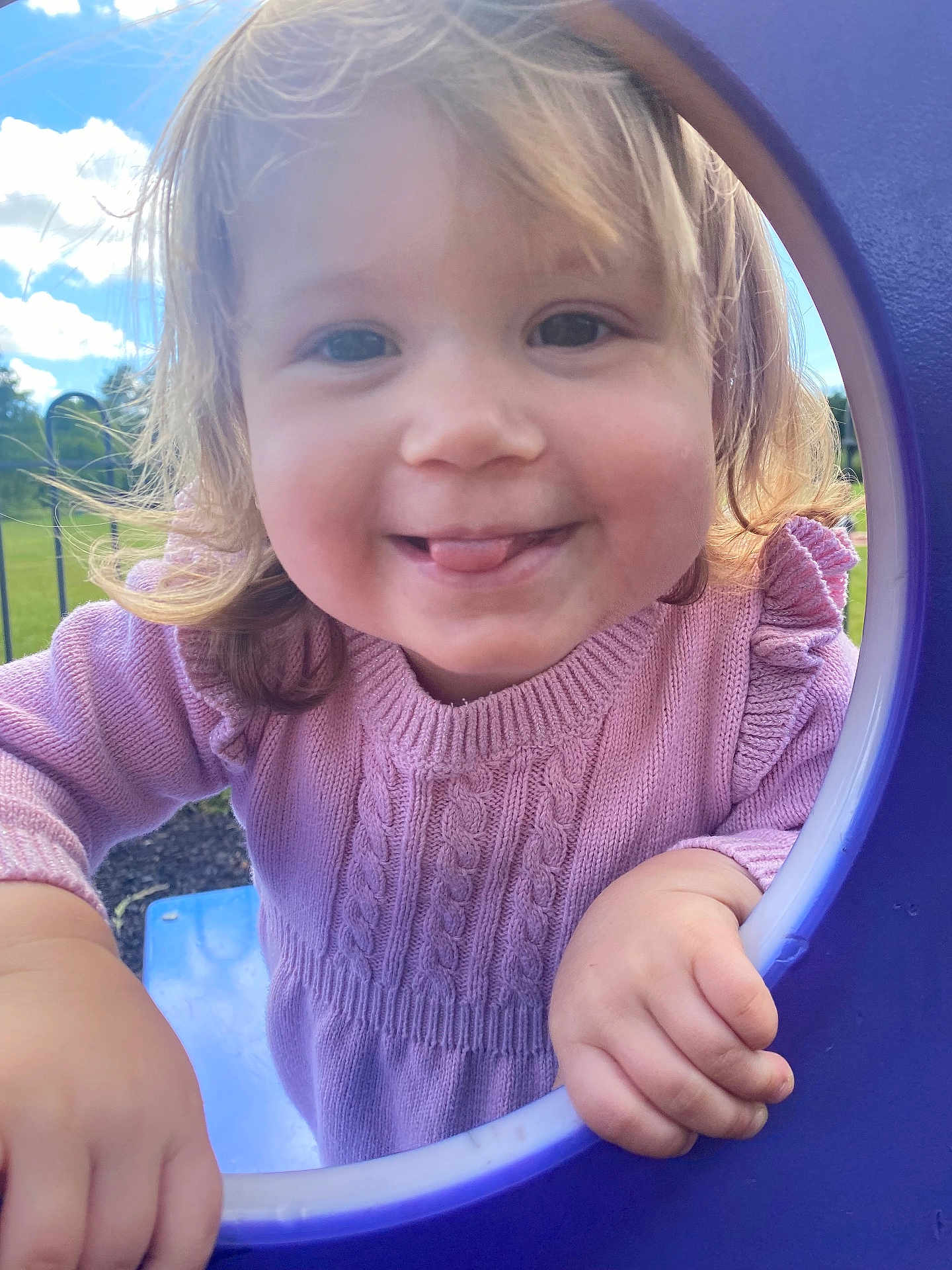 Cassie-Mai is registered to the contest to win money with this photo: child, toddler, smiling, playground, purple, sweater, pink, outdoor, sky, clouds, grass, happy, face, hands, cute, young, person, daylight, nature, fun