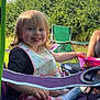 toddler, child, outdoor, camping_chair, smiling, tongue_out, bib, bowl, grass, sunlight, greenery, sky, legs, clothing, socks, person, happy, messy_face, nature, playful