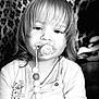 toddler, child, pacifier, beads, black_and_white, portrait, long_hair, leopard_print, clothing, cute, face, indoor, baby, young_child, expression, person, sitting, closeup, soft_light, casual