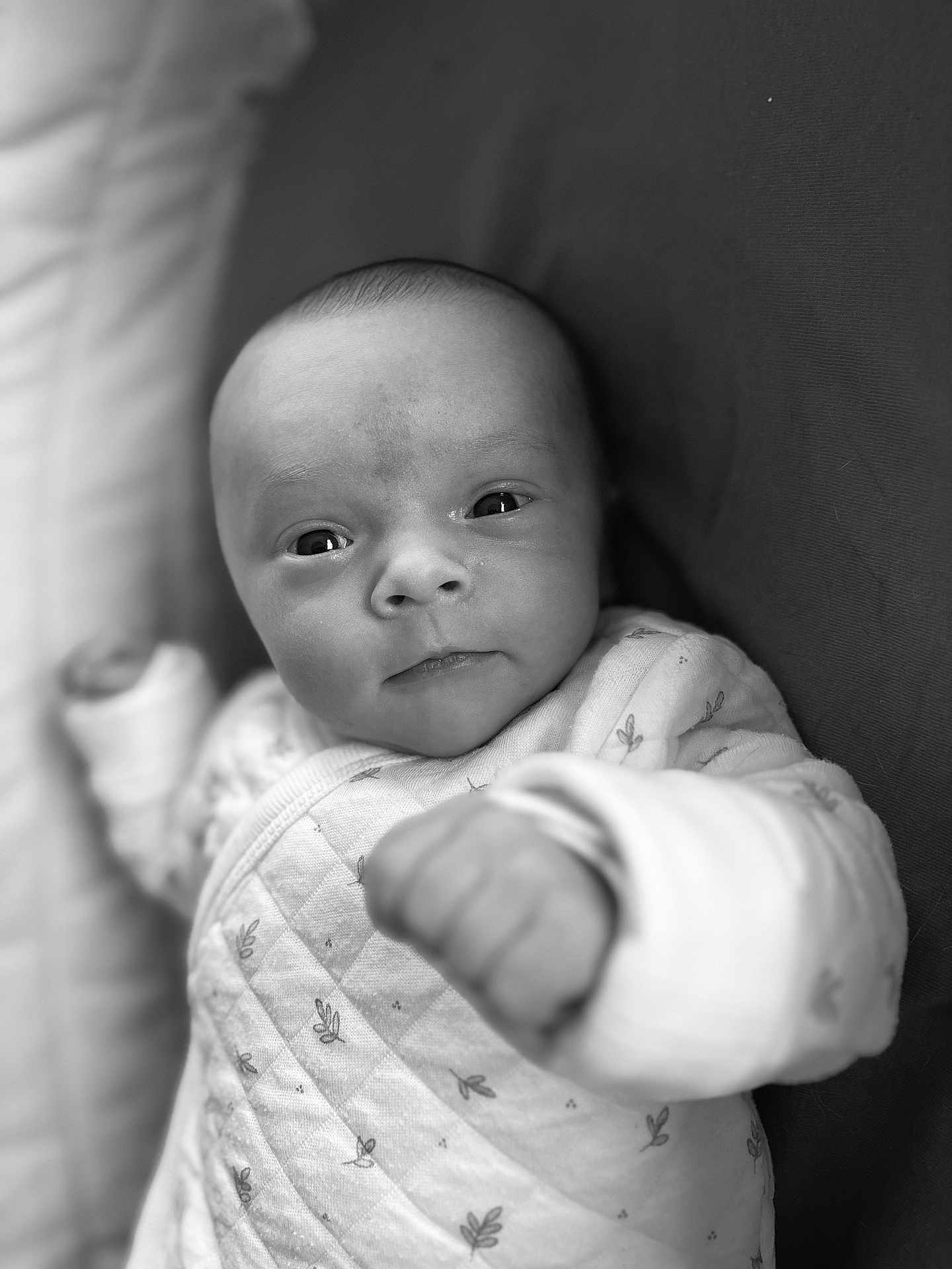 Lya participe au concours pour gagner de l'argent avec cette photo : baby, infant, face, close_up, black_and_white, onesie, fist, expression, portrait, newborn, cute, soft, young_child, sleepwear, person, child, lying_down, monochrome, small, cozy