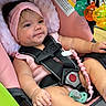baby, infant, child, stroller, pink, headband, smiling, portrait, seated, harness, seatbelt, pacifier, baby_toys, toy_rattle, colorful, outdoor, close_up, cheeks, legs, safe