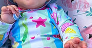 Angelica joined the competition — help win amazing prizes! baby, barefoot, child, close_up, colorful_clothing, face, floral_blanket, foot, hand, harness, infant, outdoor, pacifier_clip, pink, playful, portrait, seashell_pattern, sitting, smiling, sun_hat