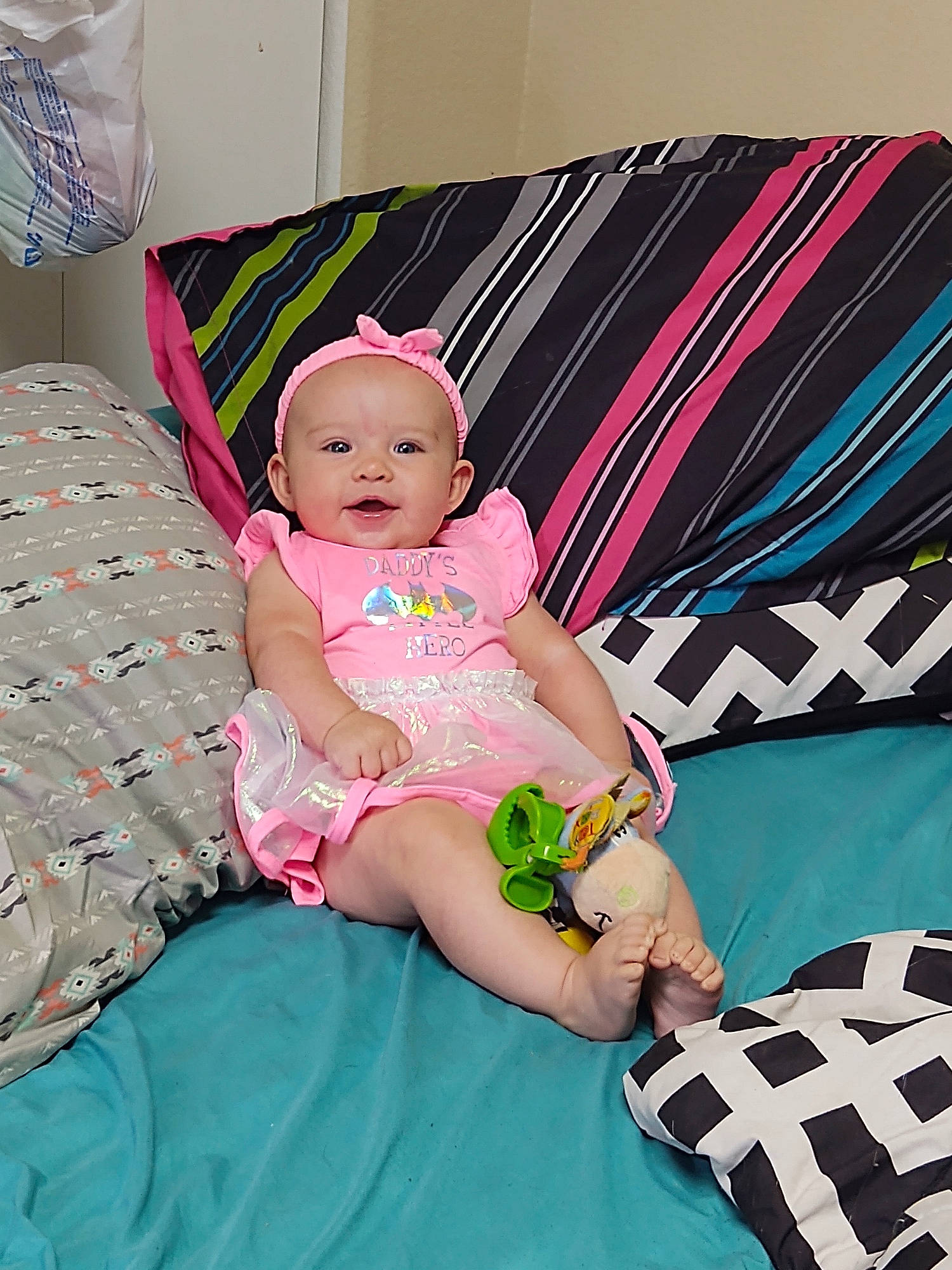Esmae joined the competition — help win amazing prizes! baby, baby_products, baby_toddler_clothing, bonnet, child, costume_accessory, cushion, hair_accessory, headband, headpiece, home_accessories, human_body, linens, person, pink, sock, textile, throw_pillow, toddler, turquoise
