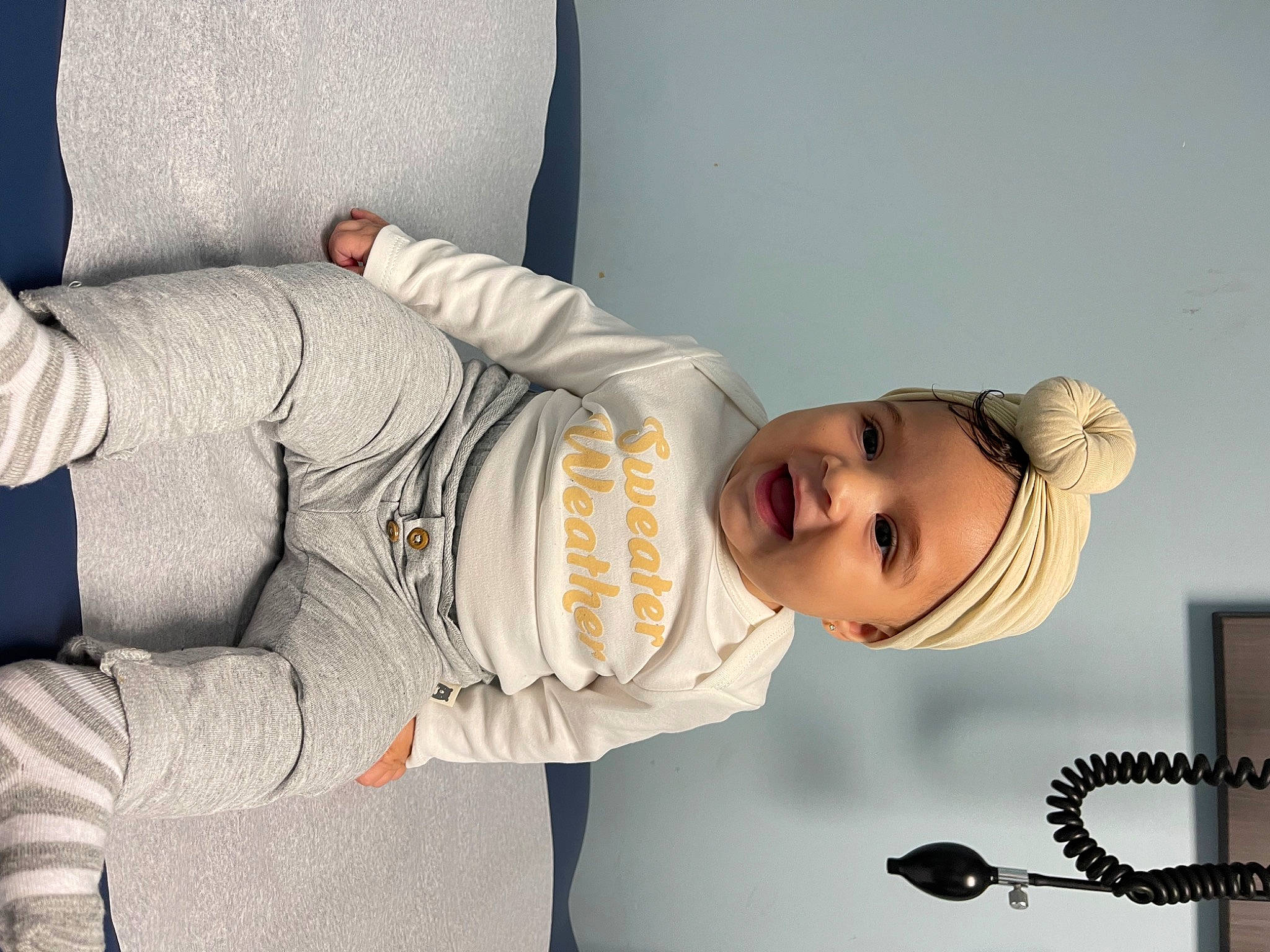 Alani joined the competition — help win amazing prizes! abdomen, baby, child, comfort, elbow, fashion_accessory, happy, hat, headgear, headwear, joint, knee, person, room, sitting, sleeve, smile, toddler, white