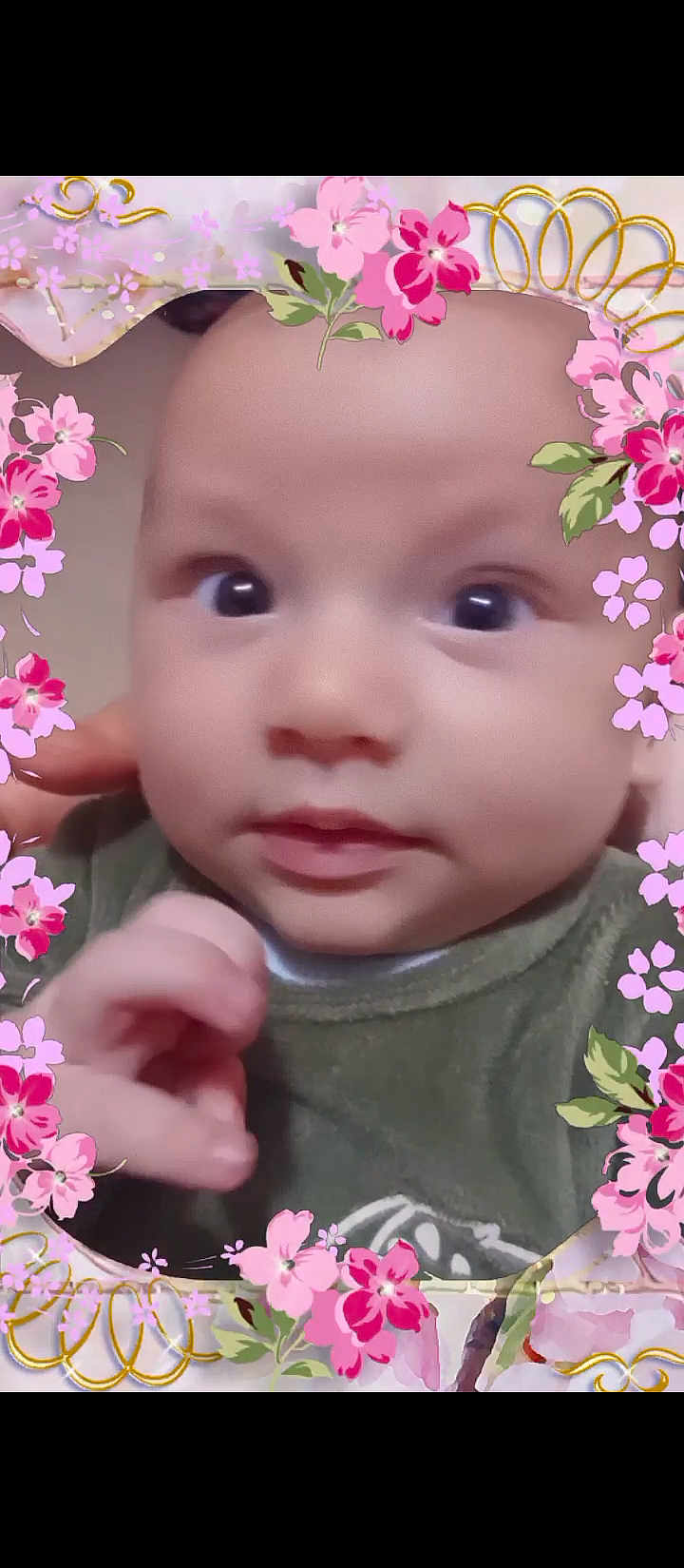 Cyriaque participe au concours pour gagner de l'argent avec cette photo : baby, infant, face, portrait, child, cute, hand, expression, wide_eyes, floral_frame, pink_flowers, green_clothing, close_up, skin, innocence, soft_lighting, young, adorable, curious, background_blur