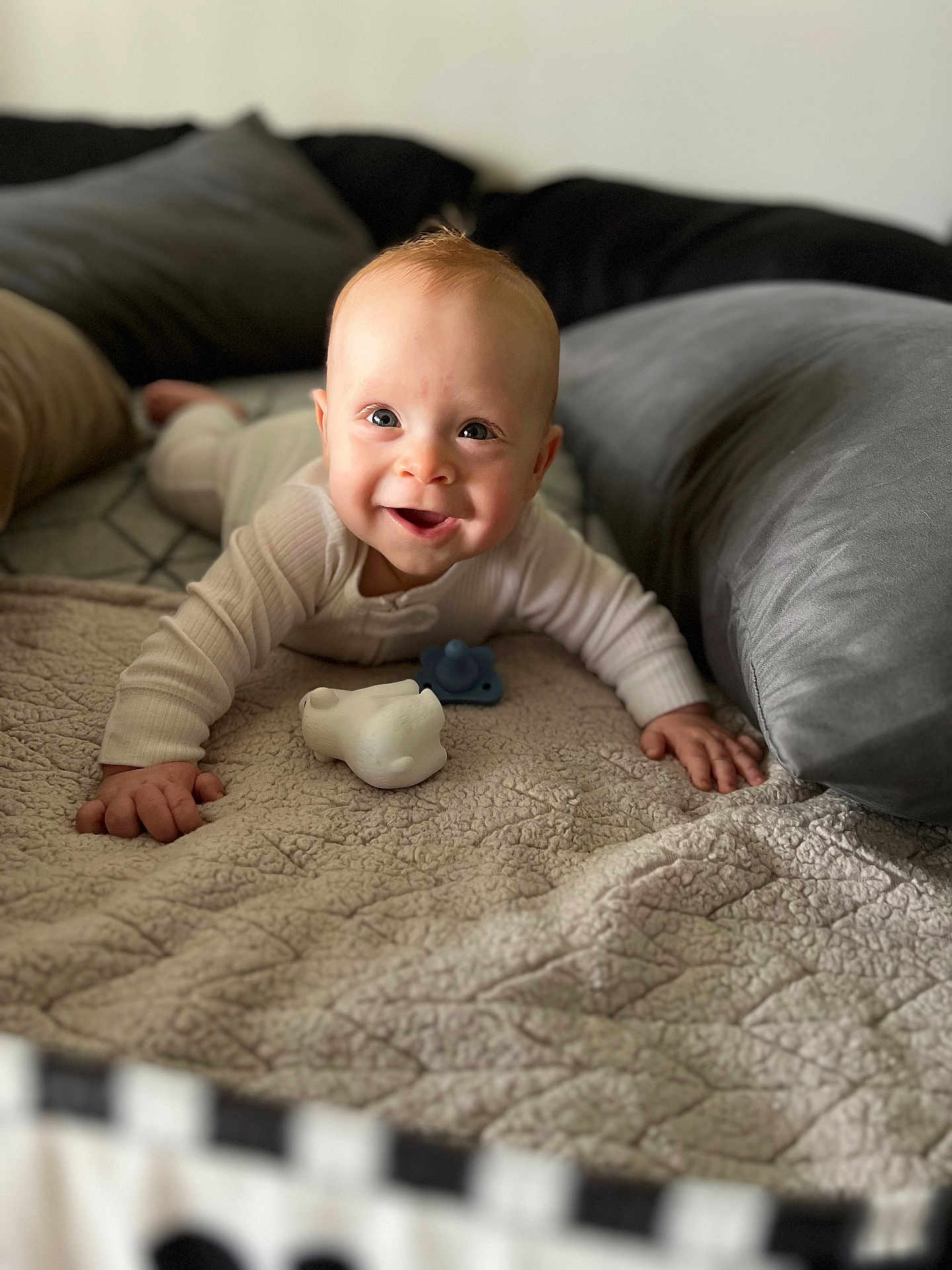 Miles is registered to the contest to win money with this photo: baby, smiling, crawling, blanket, pillow, toy, pacifier, indoor, infant, face, cute, happy, child, person, cozy, soft, clothing, head, hands, portrait