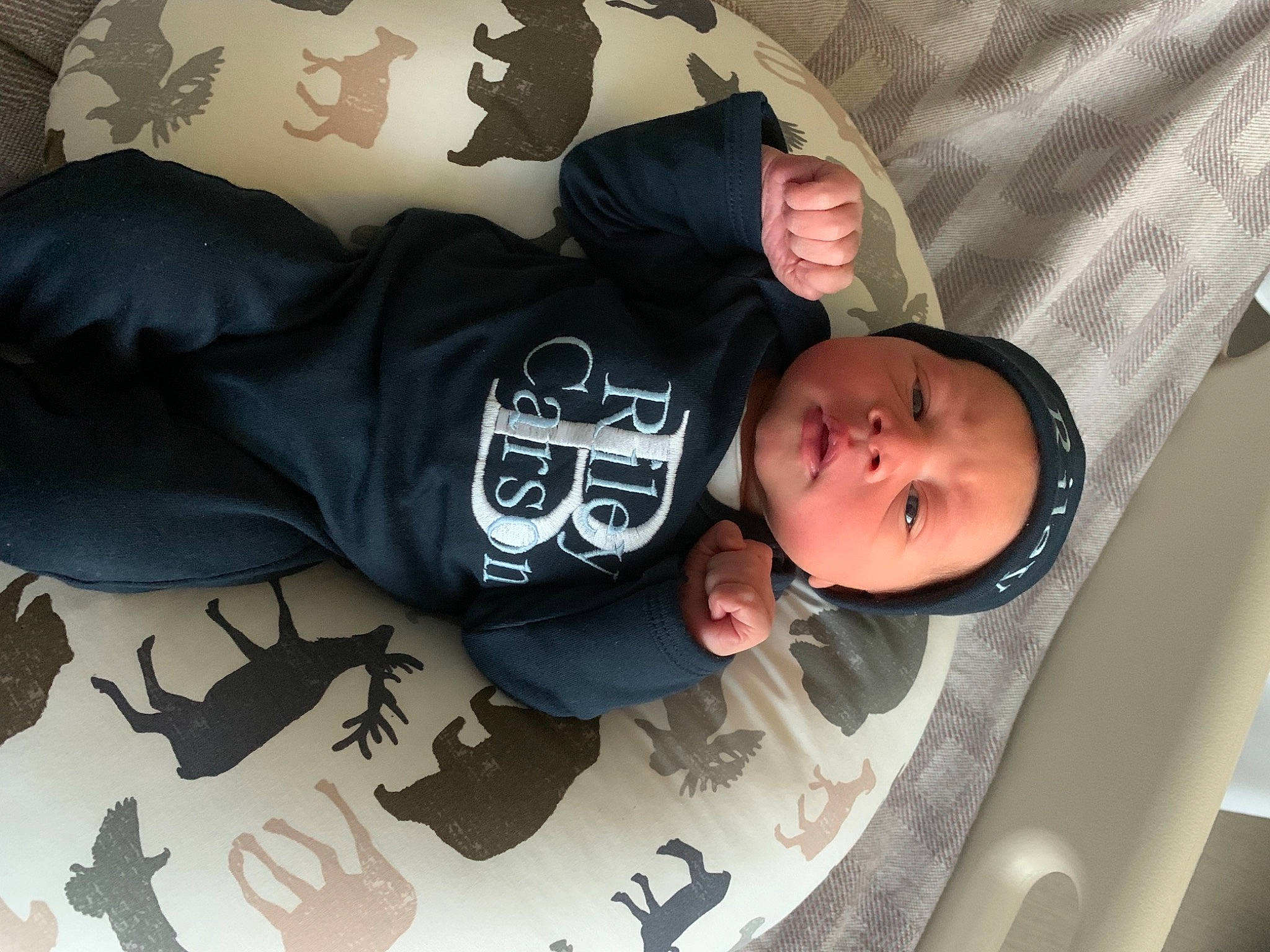 Riley is registered to the contest to win money with this photo: baby, baby_products, baby_safety, baby_toddler_clothing, cheek, child, comfort, cool, fish, font, headwear, linens, mammal, pattern, person, product, room, sitting, sleeve, t_shirt