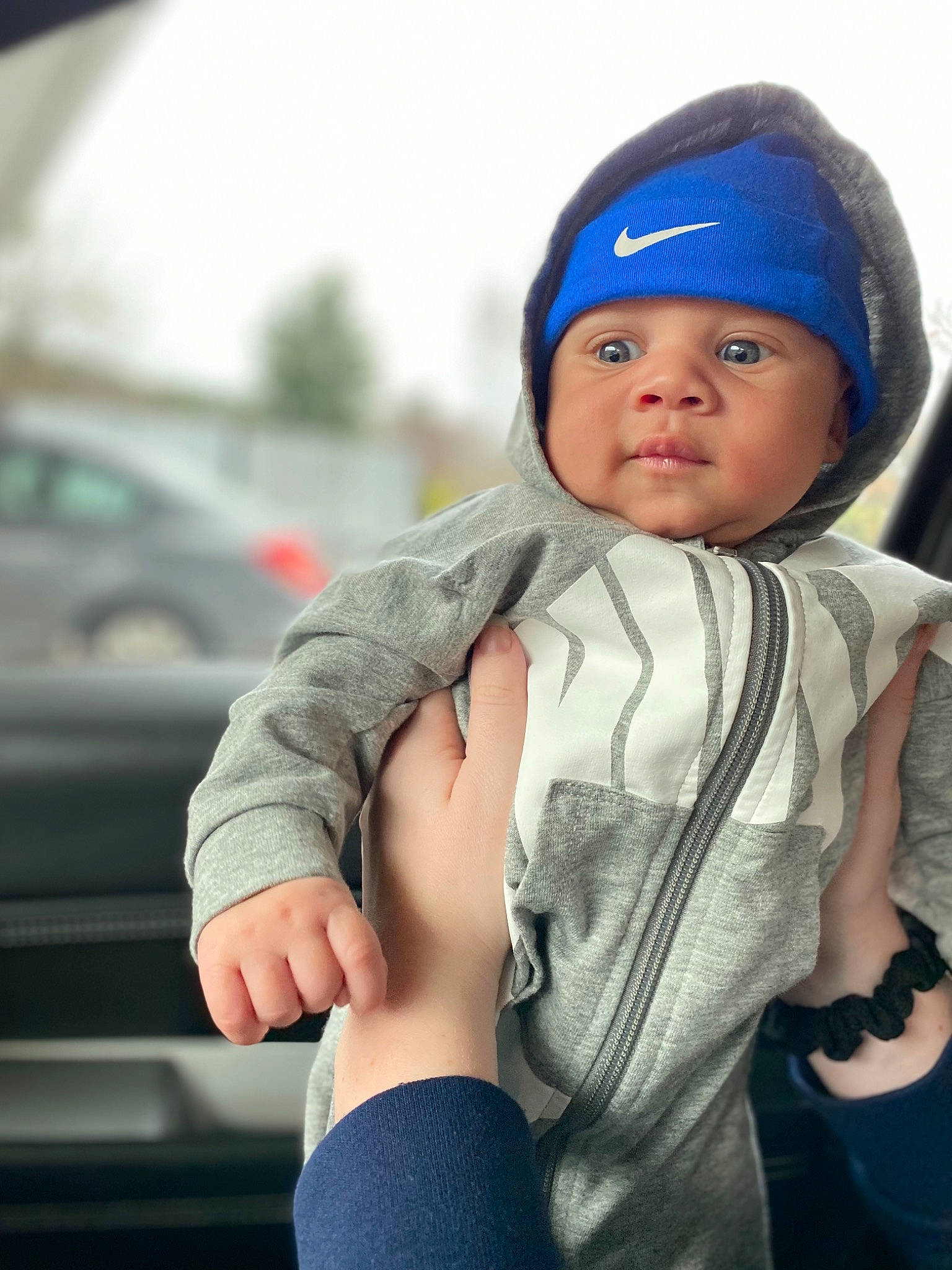 Riley is registered to the contest to win money with this photo: arm, baby, baby_products, beanie, cap, child, cool, electric_blue, fashion_accessory, finger, gesture, hand, happy, headwear, knit_cap, lip, person, sitting, sleeve, street_fashion