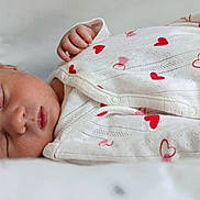 Maria participe au concours pour gagner de l'argent avec cette photo : baby, newborn, sleeping, onesie, hearts, infant, face, hand, clothing, bed, soft, peaceful, closeup, skin, person, cute, rest, child, portrait, sleep