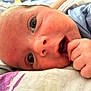 Aizen is registered to the contest to win money with this photo: baby, infant, close_up, face, hand, blue_clothing, skin, eyes, portrait, lying_down, curious, expression, newborn, child, cute, soft_light, indoors, person, young, sleeping_area