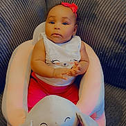 Michelle joined the competition — help win amazing prizes! baby, child, pink_bow, elephant_plush, plush_seat, couch, indoor, cute, infant, clothing, white_shirt, red_pants, smiling_face, portrait, sitting, soft_furniture, home, cozy, adorable, young_child