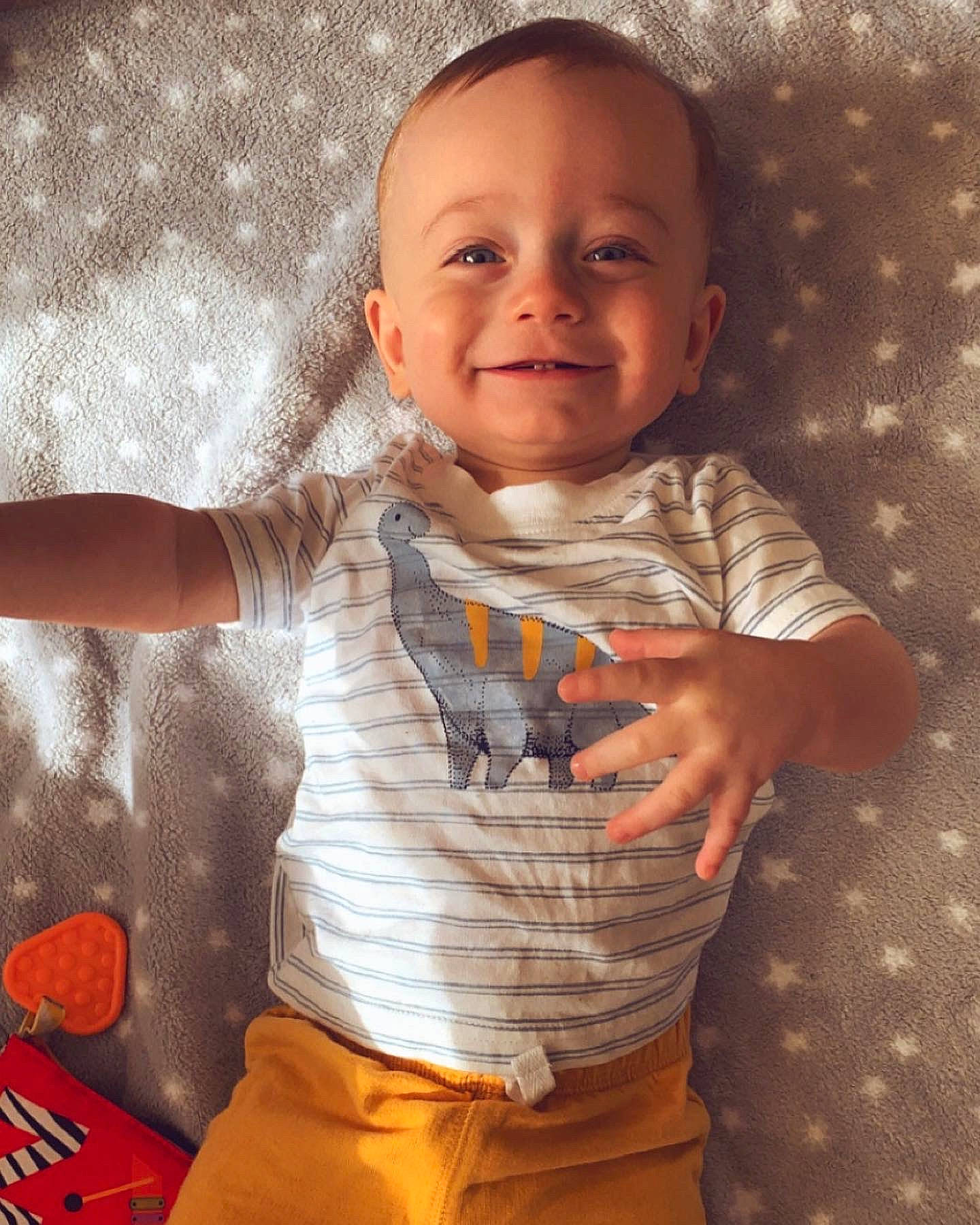Frankie is registered to the contest to win money with this photo: arm, baby_toddler_clothing, cheek, chin, clothing, dress_shirt, finger, gesture, happy, human_body, iris, joy, lip, mouth, nose, orange, person, skin, sleeve, smile