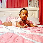 Janiyah joined the competition — help win amazing prizes! baby, bed, blanket, child, curtains, floral_pattern, headboard, indoors, infant, lying_down, person, pink, pillow, portrait, quilt, serious_expression, sleepwear, toddler, white, young_child