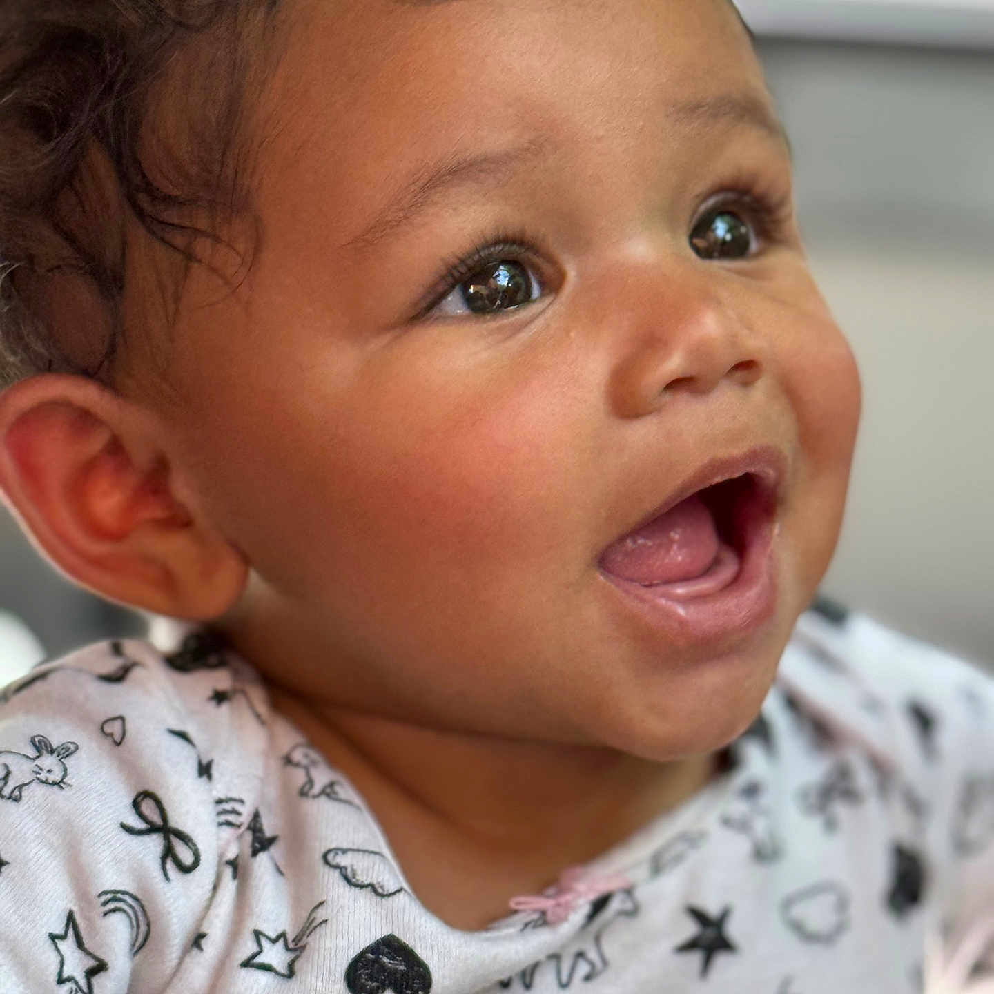 Taeleigh joined the competition — help win amazing prizes! adorable, baby, black_and_white, child, close_up, curly_hair, cute, expression, face, happy, indoors, infant, joyful, open_mouth, patterned_clothing, person, portrait, skin, sparkling_eyes, white_clothing