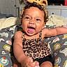 Soreiah joined the competition — help win amazing prizes! baby, infant, child, smiling, funny_face, leopard_print, headband, yellow_bow, curly_hair, foot, hand, cushion, animal_print, indoor, furniture, blanket, door, television, cabinet, cute