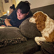 Honey joined the competition — help win amazing prizes! man, dog, couch, pillow, indoor, phone, person, brown, white, living_room, female, casual, relaxed, home, furniture, text_on_wall, blanket, sitting, conversation, focus