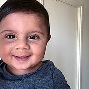 Aydan participe au concours pour gagner de l'argent avec cette photo : toddler, child, smiling, face, portrait, indoor, hair, eyes, skin, expression, clothing, shirt, happy, cute, baby, person, head, young, background, door