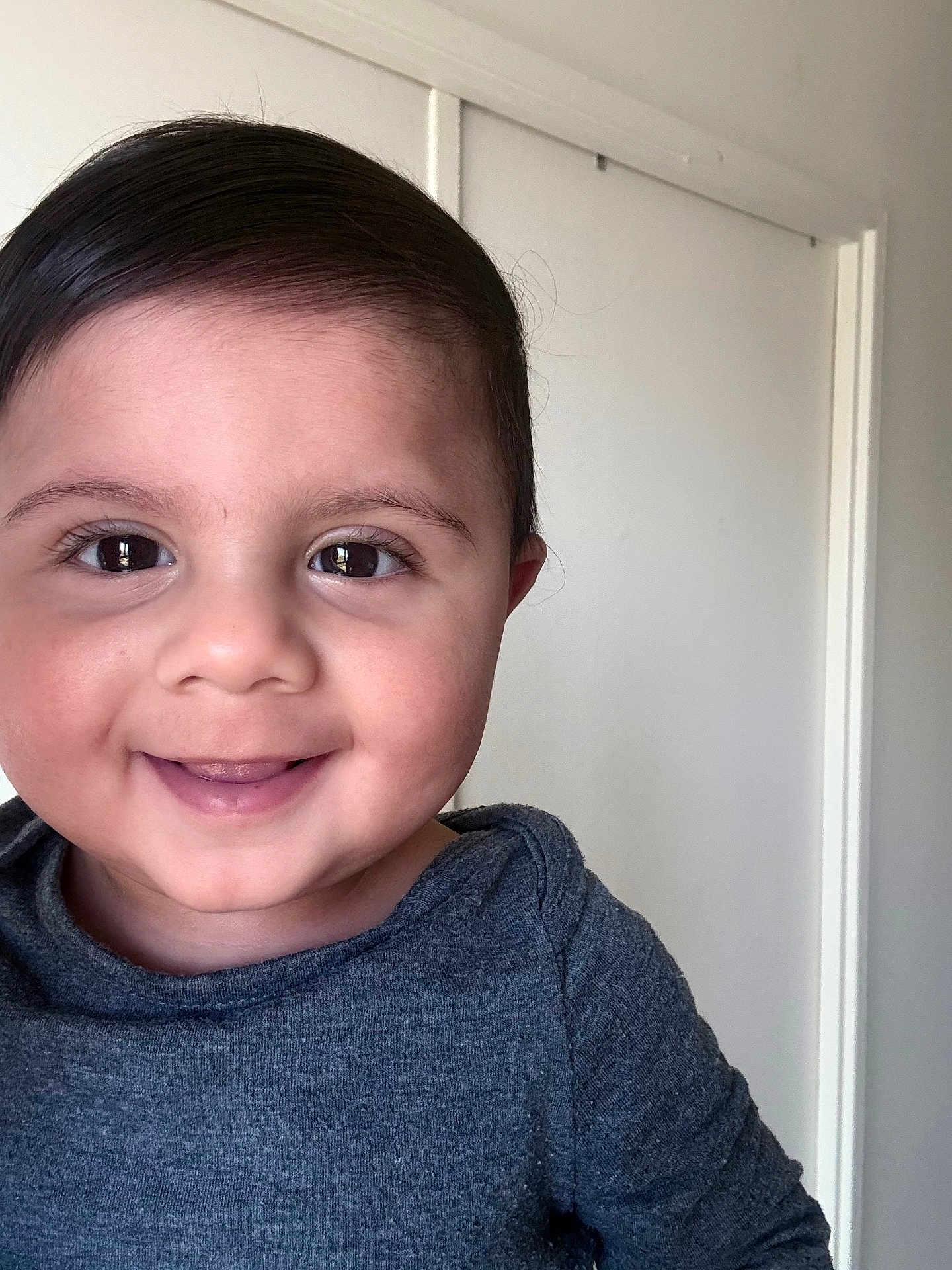 Aydan participe au concours pour gagner de l'argent avec cette photo : toddler, child, smiling, face, portrait, indoor, hair, eyes, skin, expression, clothing, shirt, happy, cute, baby, person, head, young, background, door