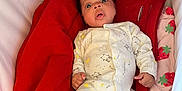 Wisdom joined the competition — help win amazing prizes! baby, infant, onesie, red_blanket, playpen, sleepwear, cute, surprised, lying_down, soft_fabric, indoor, child, newborn, face, expression, cozy, bedtime, patterned_clothing, comfort, resting