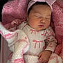 baby, sleeping, blanket, pink, headband, onesie, bow, infant, child, soft_texture, closeup, peaceful, cute, face, hand, resting, indoor, portrait, newborn, warm