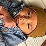 Silas is registered to the contest to win money with this photo: baby, infant, hat, brown_hat, denim_jacket, hand, face, eyes, pillow, striped_pillow, cute, clothing, closeup, portrait, child, newborn, baby_fashion, indoor, resting, soft_lighting