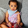 Zoe Zawadi is registered to the contest to win money with this photo: baby, child, infant, sitting, couch, toy, iron_man, dress, bib, curly_hair, barefoot, bracelet, indoors, expression, cute, portrait, person, colorful, playful, home