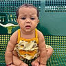 baby, child, bench, green, outdoor, cloudy_sky, yellow_clothing, cute, drool, expression, sitting, person, skin, hair, earrings, bracelet, feet, hands, summer, daytime