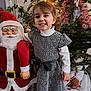 celebration, child, christmas_tree, dress, festive, festivity, gift, girl, happy, holiday_decorations, indoor, ornament, plant, portrait, ribbon, santa_claus, seasonal, smiling, tinsel, toy