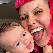 Ekhi participe au concours pour gagner de l'argent avec cette photo : baby, child, person, pink_hair, tongue_piercing, smiling, happy, indoor, close_up, face, expression, holding, cute, portrait, skin, freckles, hand, black_clothing, lamp, background