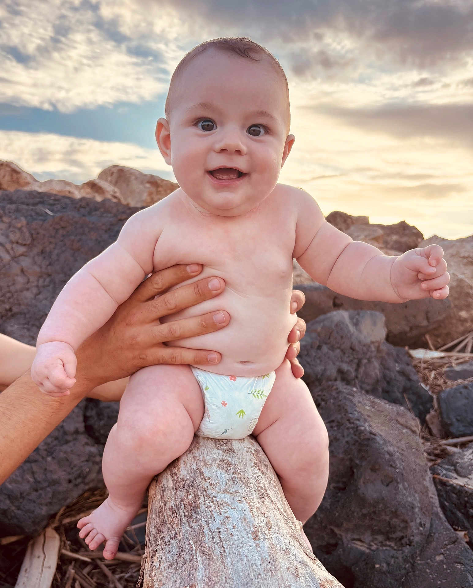 Malone a rejoint le concours — aidez-le/la à gagner de superbes lots ! baby, infant, smiling, diaper, hands, log, rocky_beach, sunset, cloudy_sky, outdoor, nature, person, happy, cute, skin, barefoot, child, portrait, summer, warm_light
