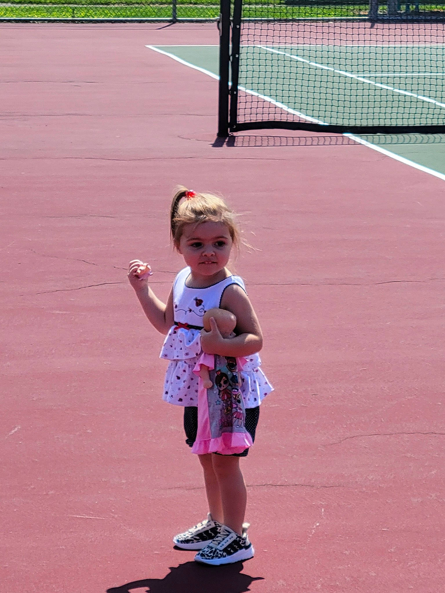 Charlee is registered to the contest to win money with this photo: asphalt, child, fun, grass, leisure, line, magenta, net, pattern, pedestrian, person, photograph, pink, play, racquet_sport, recreation, sidewalk, sports, summer, tennis