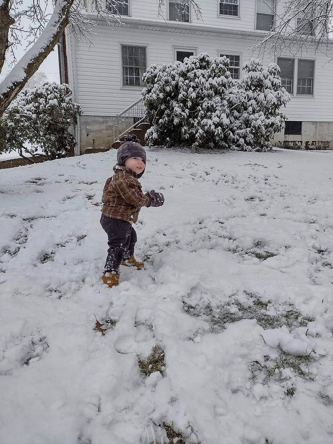 Isaiah joined the competition — help win amazing prizes! building, event, freezing, frost, garden, grass, headwear, home, house, people_in_nature, person, plant, playing_in_the_snow, precipitation, recreation, snow, toddler, tree, window, winter