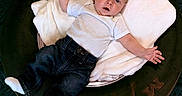 Dominic joined the competition — help win amazing prizes! baby, blanket, child, cute, dark_background, expression, face, indoor, infant, jeans, laying, pose, relaxed, round_object, small_feet, small_hands, socks, soft_texture, tire, white_shirt