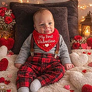 Jaxon is registered to the contest to win money with this photo: baby, infant, valentine, red_clothing, bib, plaid_pants, heart_decorations, roses, fairy_lights, lantern, candle, fluffy_rug, smiling, sitting, indoors, cute, holiday_theme, love, cozy, portrait