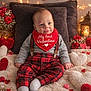 baby, infant, valentine, red_clothing, bib, plaid_pants, heart_decorations, roses, fairy_lights, lantern, candle, fluffy_rug, smiling, sitting, indoors, cute, holiday_theme, love, cozy, portrait